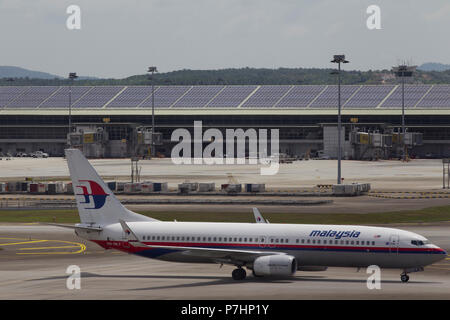 Un Malaysian Airlines Boeing 737 taxi all'edificio del terminal dopo l'atterraggio all'Aeroporto Internazionale di Kuala Lumpur in Malesia. Foto Stock