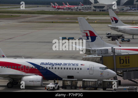 Un Malaysian Airlines Boeing 737 taxi all'edificio del terminal dopo l'atterraggio all'Aeroporto Internazionale di Kuala Lumpur in Malesia. Foto Stock