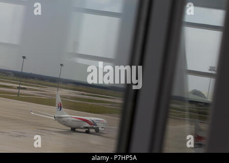 Un Malaysian Airlines Boeing 737 taxi all'edificio del terminal dopo l'atterraggio all'Aeroporto Internazionale di Kuala Lumpur in Malesia. Foto Stock