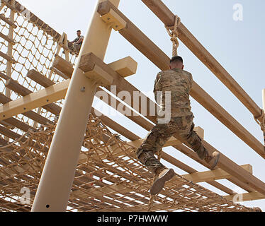 Xxxviii Supporto Brigata Sgt. Zachary Verde si arrampica la corda all'inizio del Airborne ostacolo corso durante la U.S. Esercito centrale guerriero migliore concorso a Camp Beuhring, Kuwait, 29 giugno. Il verde è andato a vincere il guerriero della migliore concorrenza. Foto Stock