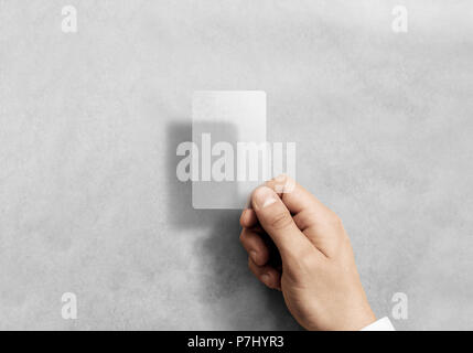 Tenere in mano blank verticale carta traslucida mockup con angoli arrotondati. Plain Cancella chiamata-card mock up modello braccio di contenimento. Plastica acrilica trasparente biglietti da visita il display anteriore. Foto Stock