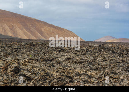 La roccia vulcanica dal flusso di lava. Campo di lava nel Parco Nazionale di Timanfaya a Lanzarote, Isole Canarie, Spagna. Foto Stock