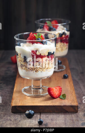 Parfait di yogurt fatto con lo yogurt greco, frutti di bosco freschi e avena. Foto Stock