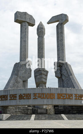 Il Partito dei Lavoratori monumento aka il monumento alla fondazione di partito con il martello, la falce e il pennello con murali di Pyongyang Foto Stock