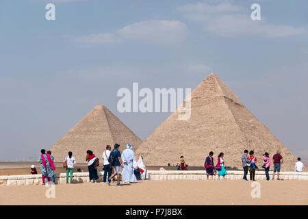 I turisti internazionali presso la Grande Piramide di Giza (sinistra) e la piramide di Khafre (a destra) al sito di Giza in Egitto. Foto Stock