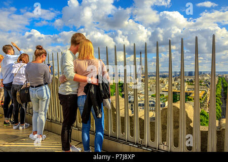 Parigi, Francia - luglio 2, 2017: coppia romantica in cerca della Torre Eiffel in la distanza dalla parte superiore del Arc de Triomphe. Punto di riferimento nella skyline di Parigi, in Francia, in Europa. Giornata soleggiata con cielo blu. Foto Stock