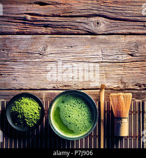 Matcha tè in una ciotola e mescolare con una frusta di bambù e polvere verde Foto Stock