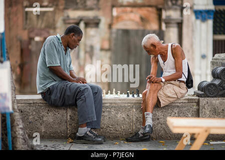 Cubanos incentrato su una partita a scacchi in un rumoroso, affollato mercato all'aperto all'Avana. Foto Stock