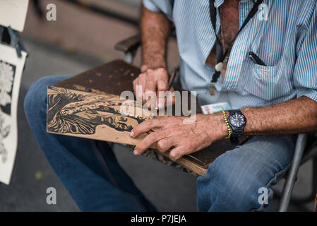 Un artista cubano opere su le sue stampe a un mercato all'aperto all'Avana. Foto Stock