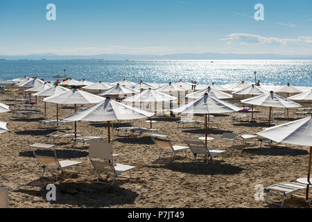 Vista del mare di fronte bianco, aperto ombrelloni e lettini per il sole, la spiaggia di Lignano Foto Stock
