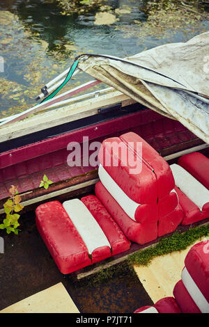 Vecchio alterò il bianco e il rosso sedi sul motoscafo con telone Foto Stock