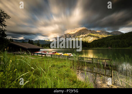 Noleggio barca con pedalò e barca rifugio al lago Lautersee, montagne Karwendel in background, cloud-drift, Esposizione lunga Foto Stock