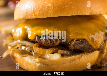 In casa di Oklahoma cipolla fritti cheeseburger con il formaggio Cheddar Foto Stock