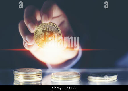 Mano d'uomo azienda golden Bitcoins e nuovo denaro virtuale concetto e la crescita finanziaria concetto su sfondo grafico Foto Stock