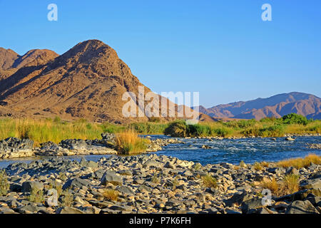 Stony alveo del fiume Orange / Oranjerivier confine (fiume) in Richtersveld, al lato opposto della Namibia, Namaqua, Sud Africa Foto Stock