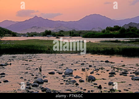 Stony alveo del fiume Orange / Oranjerivier confine (fiume) in Richtersveld in atmosfera serale, al lato opposto della Namibia, Namaqua, Sud Africa Foto Stock