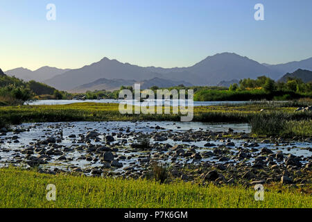 Stony alveo del fiume Orange / Oranjerivier confine (fiume) in Richtersveld, al lato opposto della Namibia, Namaqua, Sud Africa Foto Stock