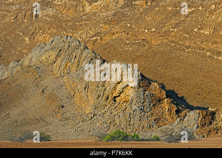 Altamente eroso, ondulate dispiegata creste rocciose a secco su un fiume di Brandber West in Namibia, Damaraland Foto Stock