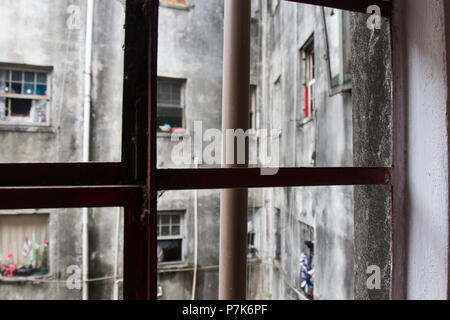Da un metallico marcio sul telaio di una finestra di un edificio usurato la vista delle pareti incrinate, appartamento windows e tubi. San Paolo. Il Brasile. N. persone. Foto Stock