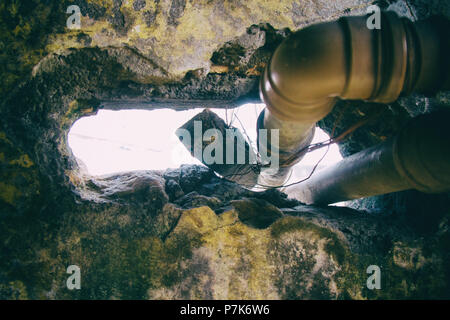 Grande buco in un muro rotto viene utilizzato del passaggio di tubazioni di acqua in un condannato edificio utilizzato come slum da alloggi sociali in movimento. San Paolo. Il Brasile. N. p Foto Stock