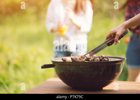 Grill in piedi sul tavolo da picnic all'aperto. Foto Stock