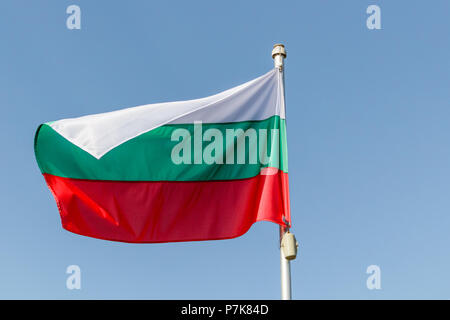 Sventola bandiera della Bulgaria contro il cielo blu con copia spazio sulla sinistra Foto Stock