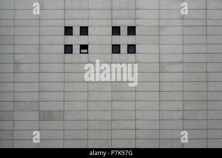 Facciata di un moderno commerciale e dello shopping ed edificio rettangolare con le lastre di cemento e piccole finestre quadrate, Foto Stock