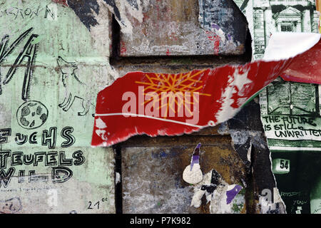 Close-up di un cartellone con dei frammenti di carta da poster e cartelloni, nonché scrawled slogan, Foto Stock