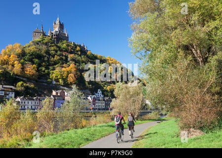I ciclisti presso la Mosella, castello imperiale in autunno, Cochem, Renania-Palatinato, Germania Foto Stock