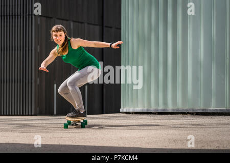 Teen con longboard, 18 anni, femmina, ambiente urbano Foto Stock