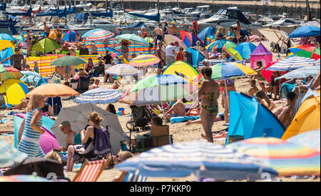Lyme Regis, Dorset, Regno Unito. Il 7 luglio 2018. Regno Unito: Meteo caldo cocente sole di Lyme Regis. Sunseekers gregge alla spiaggia per godere ancora più caldo del fine settimana di sole e cielo blu chiaro nella località balneare di Lyme Regis su cosa è impostata per il giorno più caldo dell'anno finora. Credito: Celia McMahon/Alamy Live News Foto Stock