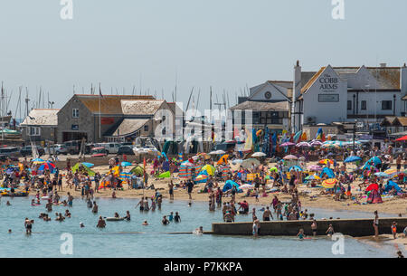 Lyme Regis, Dorset, Regno Unito. Il 7 luglio 2018. Regno Unito: Meteo caldo cocente sole di Lyme Regis. Sunseekers gregge alla spiaggia per godere ancora più caldo del fine settimana di sole e cielo blu chiaro nella località balneare di Lyme Regis su cosa è impostata per il giorno più caldo dell'anno finora. Credito: Celia McMahon/Alamy Live News Foto Stock