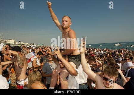 Brighton, Regno Unito. Il 7 luglio 2018. Per gli appassionati di calcio sulla spiaggia di Brighton guardando il grande schermo sulla spiaggia attraverso le barriere Credito: Rupert Rivett/Alamy Live News Foto Stock