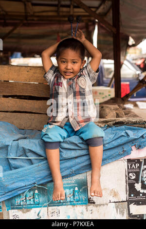 Little Boy nel mercato di Kutacane graffi sul retro Foto Stock