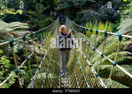 Donna sulla Birmania ponte di sospensione nella giungla, il Lost Gardens of Heligan, a St Austell, Cornwall, England, Regno Unito Foto Stock