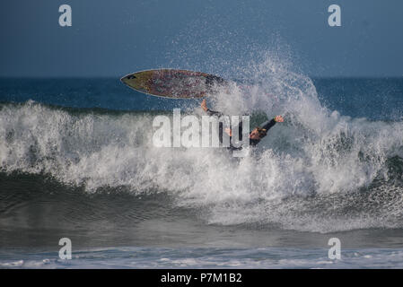 Giovani California surfer cadere l'onda come suo bordo va battenti durante le prime parti del sud gonfiano. Foto scattata a Surfer's punto in Ven Foto Stock