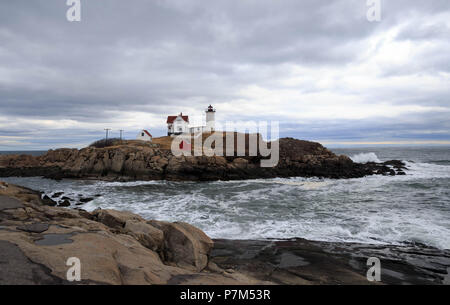Cape Neddick faro sorge su Nubble isola con le onde che si infrangono sulla spiaggia rocciosa Foto Stock