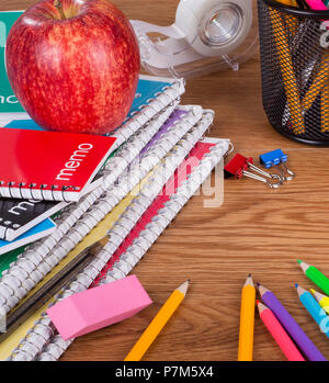 Assortimento di scuola e di forniture per ufficio su una superficie in legno Foto Stock