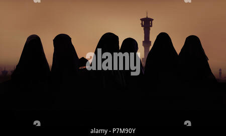Silhouette di donne musulmane e di ragazze in costumi islamici, burqa Foto Stock