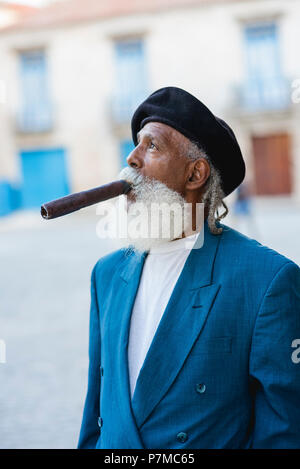 Un impeccabilmente vestito che fumare un sigaro gigante nelle strade di l'Avana, Cuba. Egli è stato presentato nel National Geographic Traveler anni fa. Foto Stock