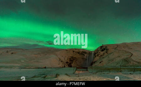 Luci del nord oltre Skogafoss cascata, Sud dell'Islanda, Islanda Foto Stock