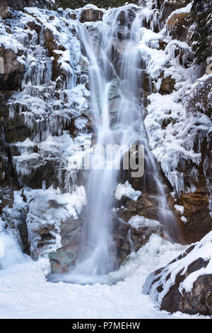 Vo' cascata vicino a Schilpario ghiacciato in inverno. Val di Scalve, provincia di Bergamo, Lombardia, Italia, Foto Stock