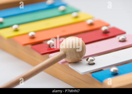 Mazzuolo in appoggio su un colorato per bambini xilofono Foto Stock