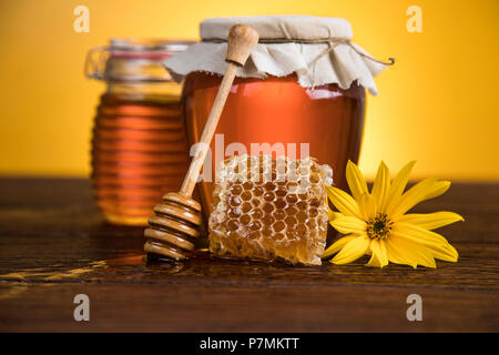 Vaso pieno di miele fresco e favi Foto Stock