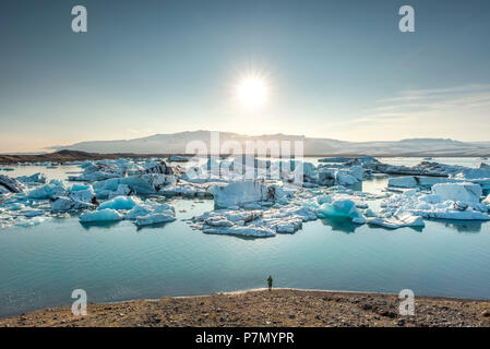 Persona ammirando gli iceberg alla laguna glaciale di Jokulsarlon. Islanda Orientale, Islanda Foto Stock