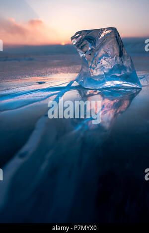 Un cubo di ghiaccio sul piatto lago surgelati al tramonto, Baikal, Regione di Irkutsk, Siberia, Russia Foto Stock