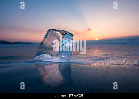 Un cubo di ghiaccio sul piatto lago surgelati al tramonto, Baikal, Regione di Irkutsk, Siberia, Russia Foto Stock