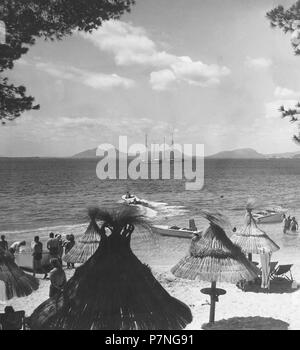 Islas Baleares. Mallorca. Bañistas en la playa de Formentor. Sombrillas de Paja. Años 1950. Foto Stock