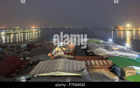Villaggio galleggiante in Sriracha sul Golfo di Thailandia durante la notte con le luci provenienti dalle navi all'orizzonte Foto Stock