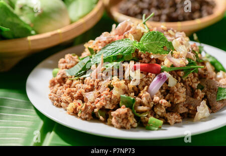 Piccante di carne macinata di maiale mix Zanthoxylum rhetsa con verdure fresche, cibo del nord della Thailandia, il fuoco selettivo Foto Stock